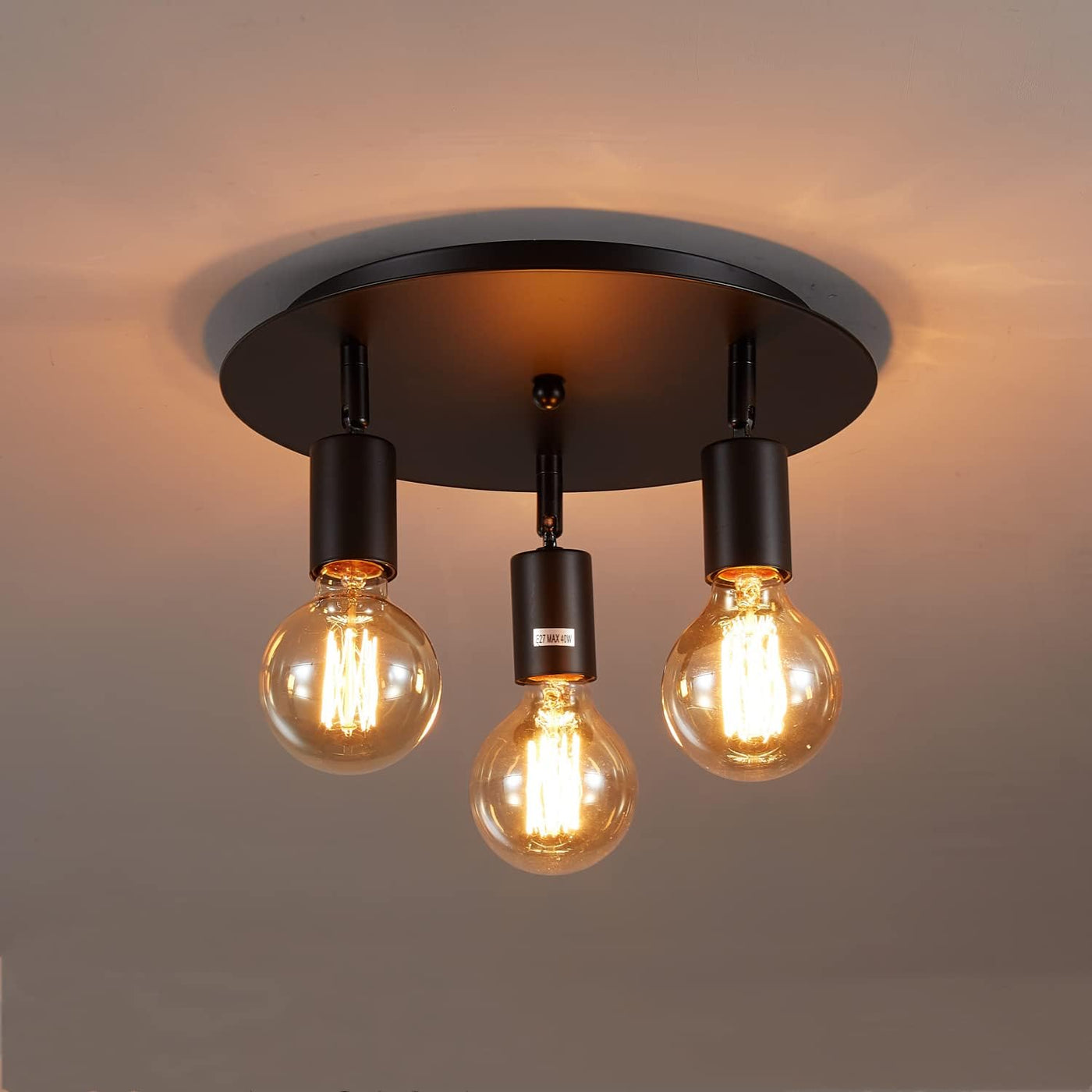 Ceiling light fixture with three lit bulbs on a neutral background