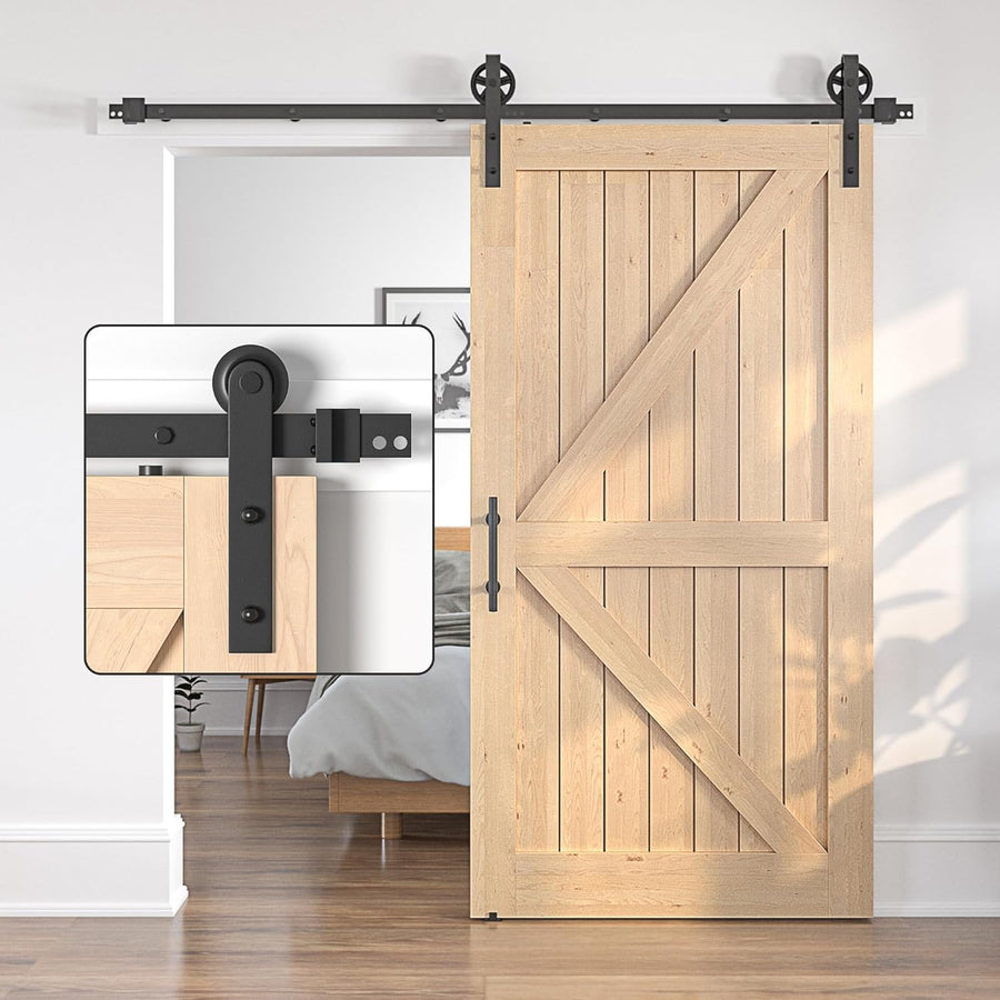 Wooden sliding barn door with black hardware in a room setting.