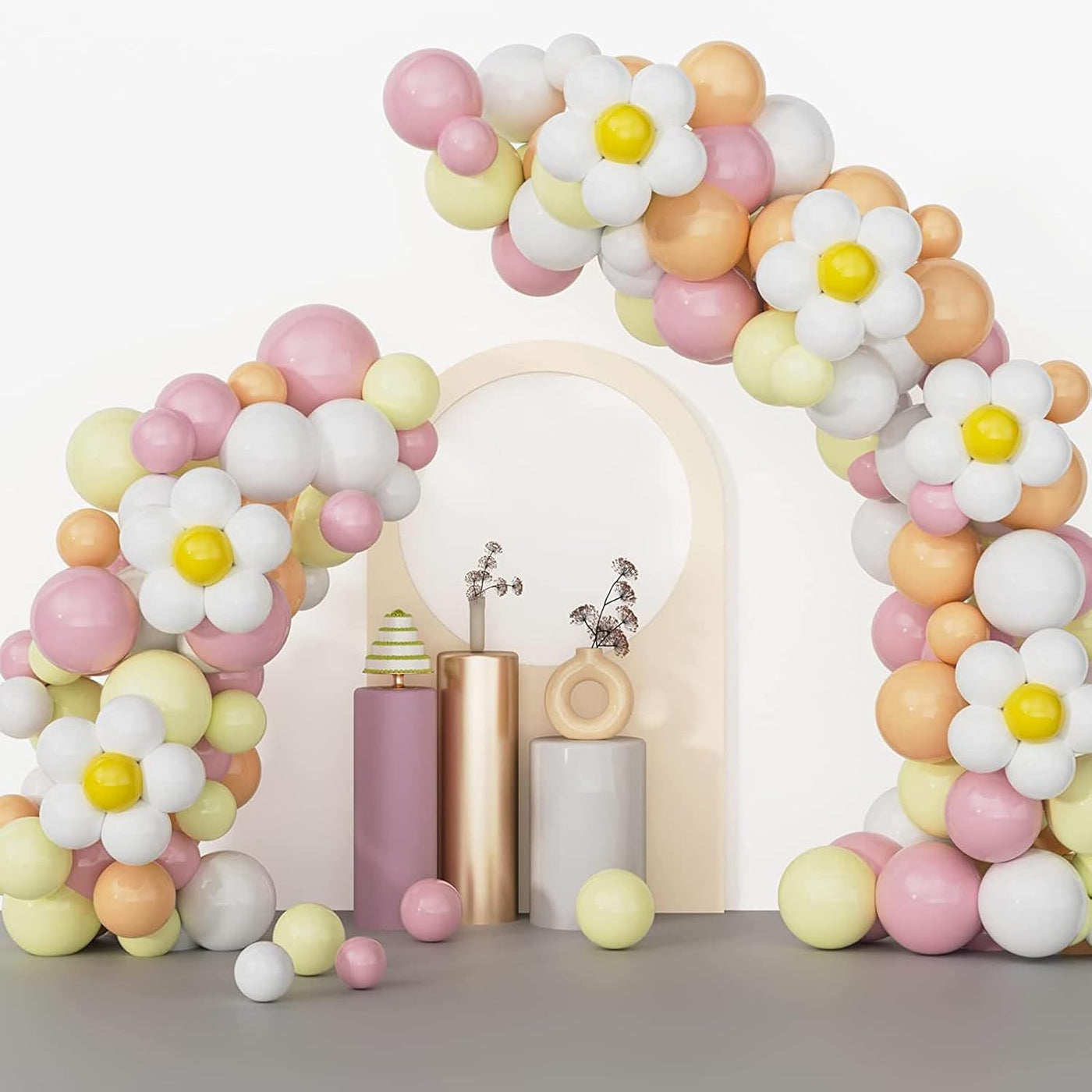 Pastel balloon arch with flower decorations on a neutral background