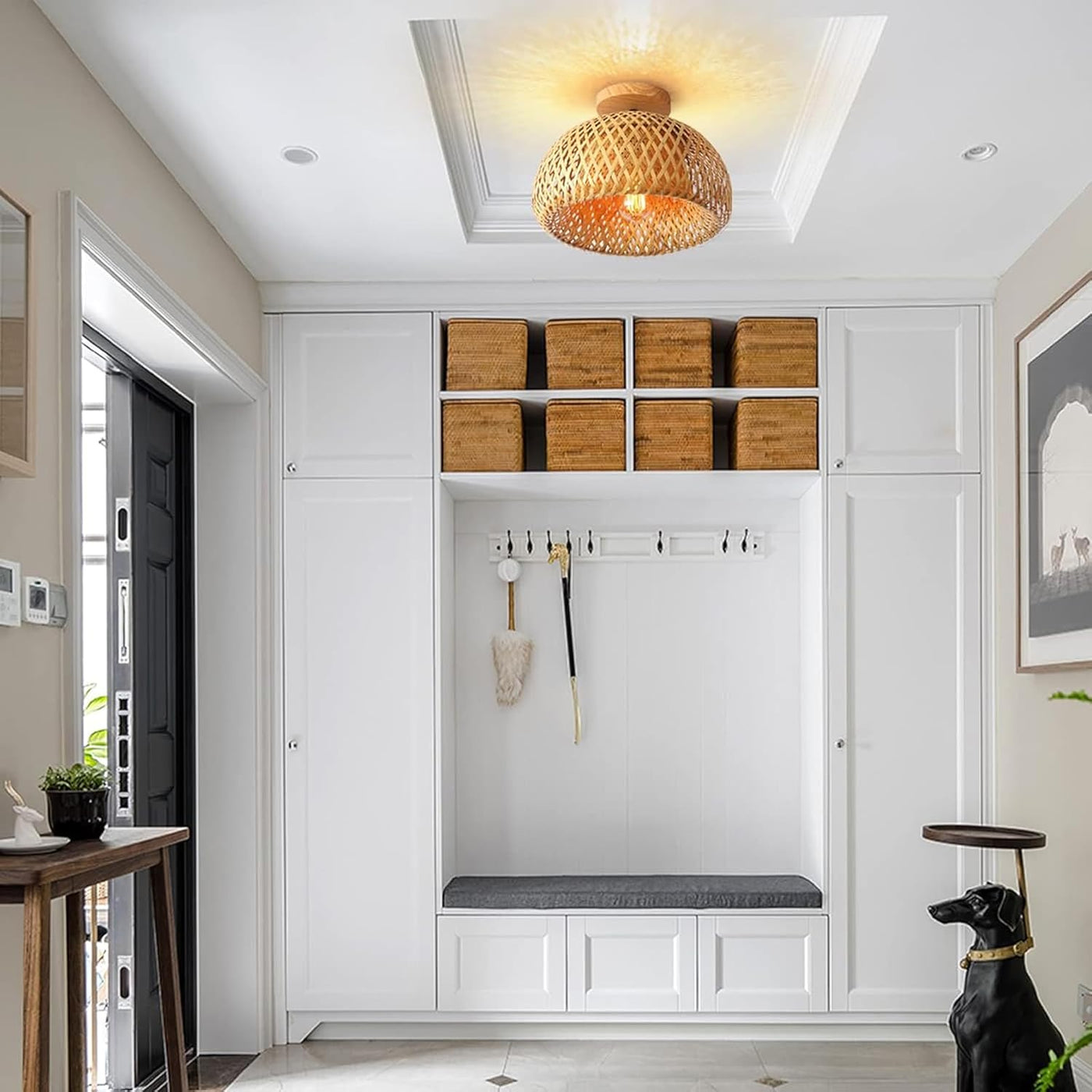 Modern entryway with white cabinets, wooden boxes, and a bench.