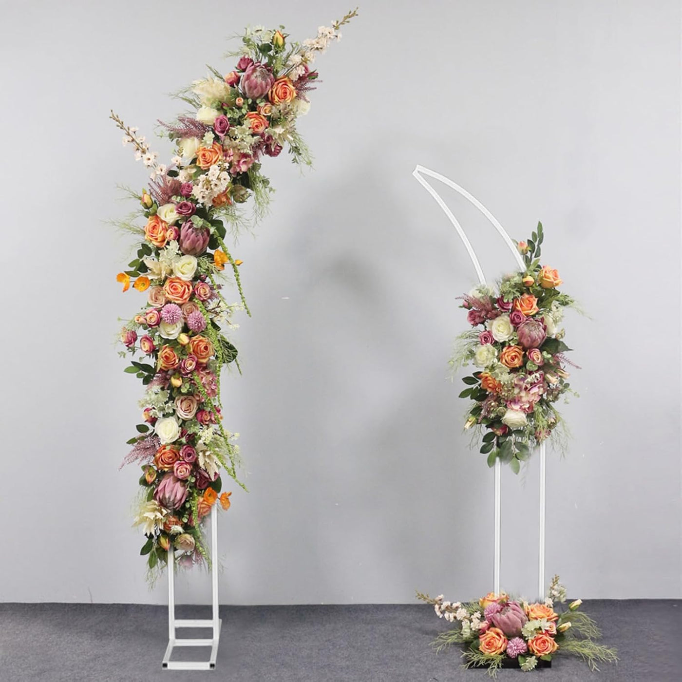 Floral arch and decorations on stands against a gray background