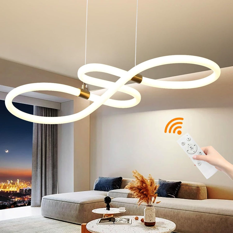 Modern white pendant LED light with gold accents, hanging over a sofa in a living room, with a hand holding a remote control.