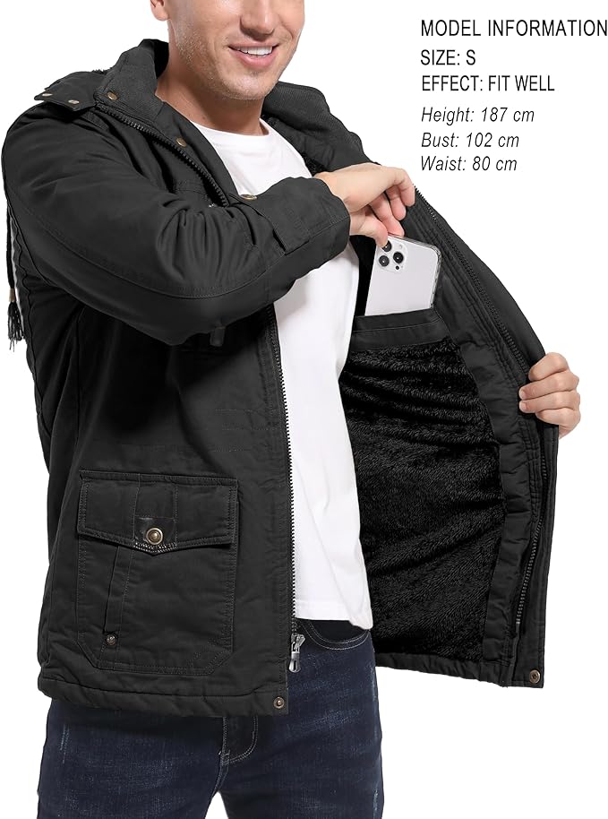 Person wearing a black jacket with a phone pocket, holding a phone.