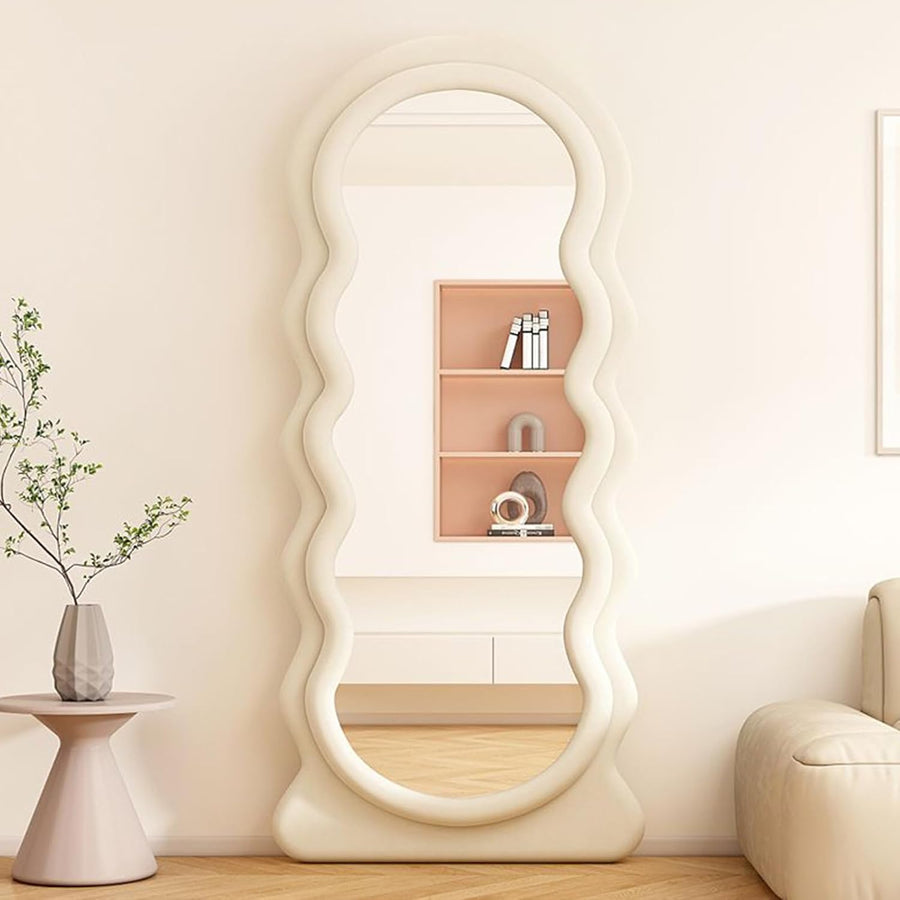 Decorative floor mirror with wavy design in a living room setting.