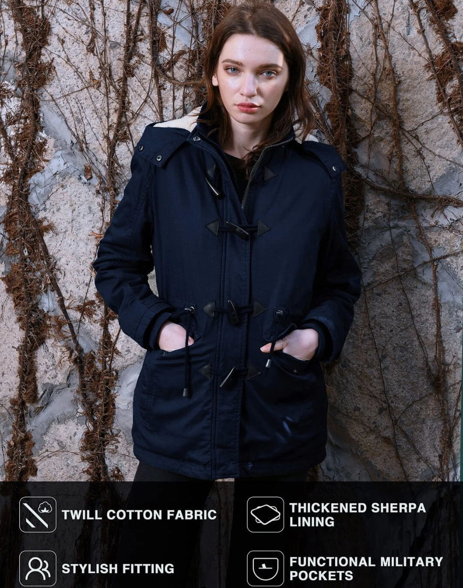 Woman wearing a navy blue coat against a textured wall.