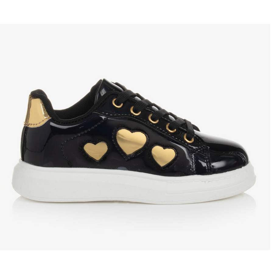 Children's black patent trainers with gold heart details and a white non-slip sole.