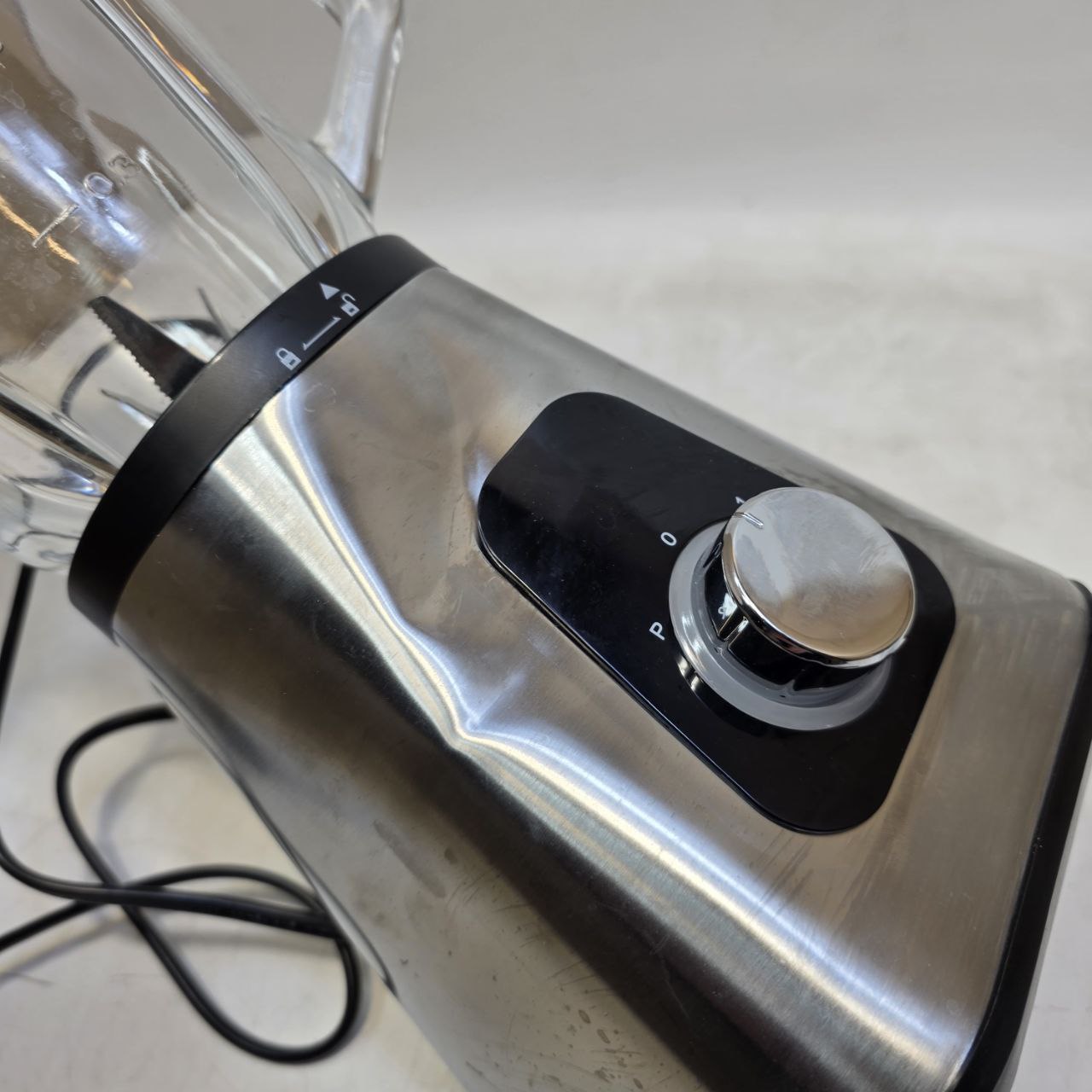 Stainless steel kitchen mixer on a light gray surface