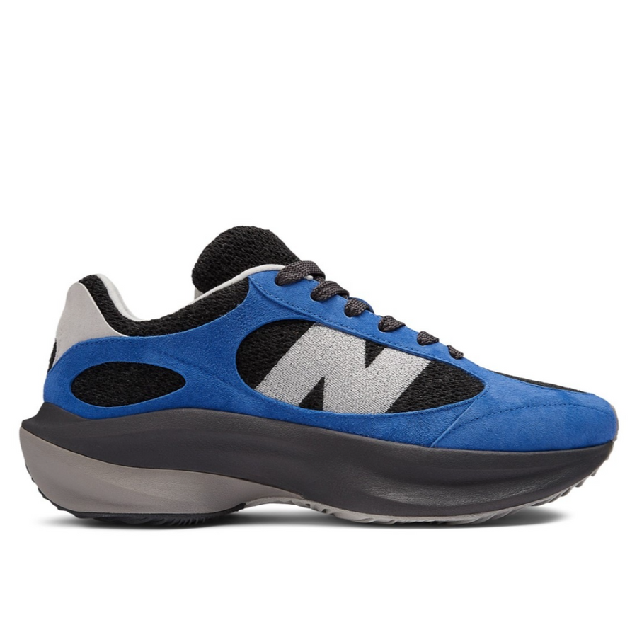 A pair of New Balance WRPD Runner sneakers in Marine Blue, featuring a black mesh base with blue suede overlays and an oversized grey 'N' logo.