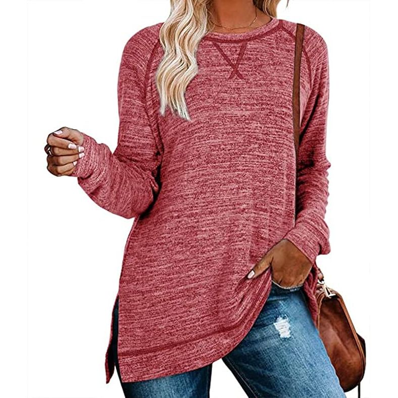 Person wearing a maroon long-sleeve top and blue jeans with a brown bag on a white background