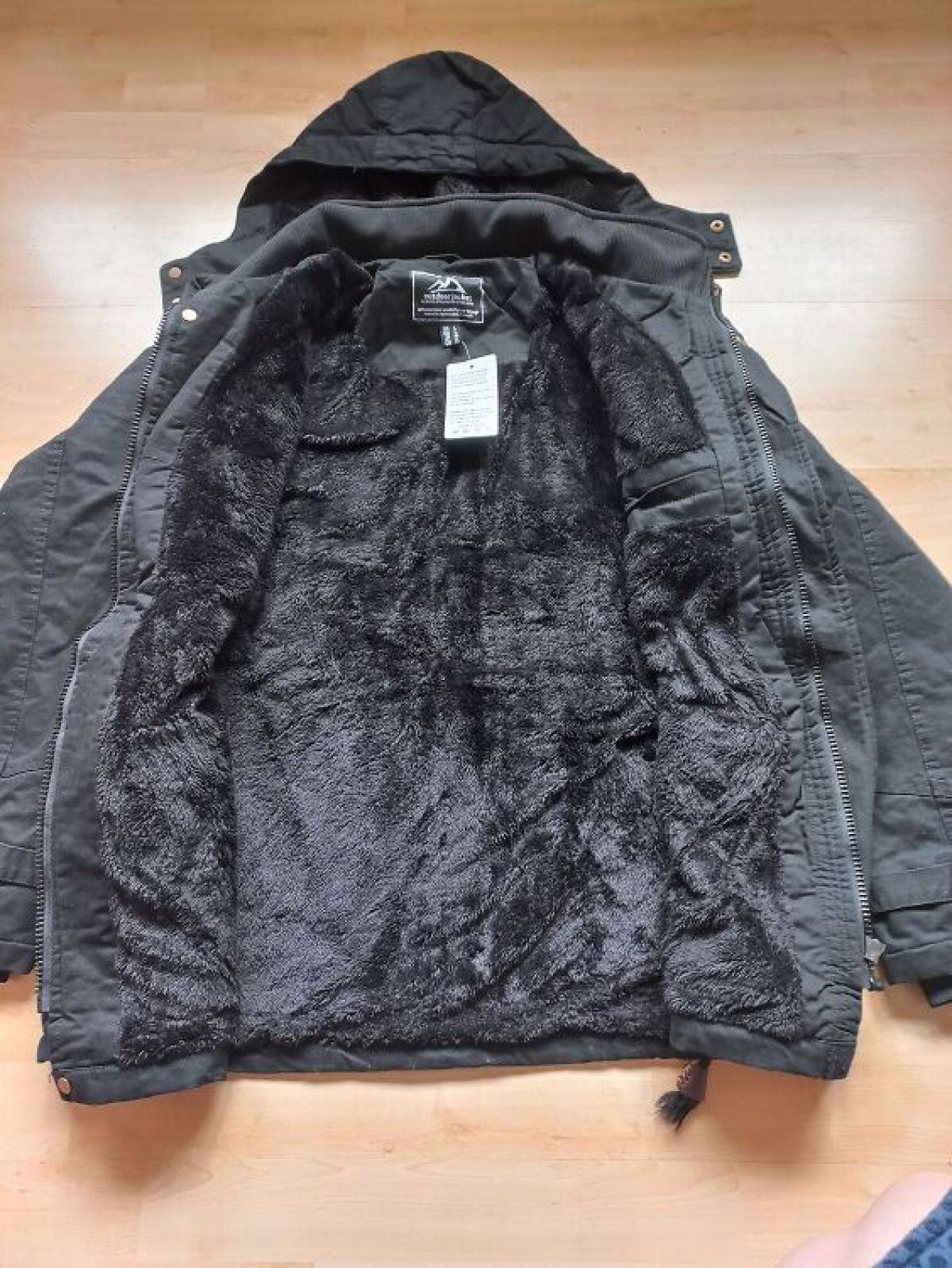 Black jacket with a hood on a wooden floor