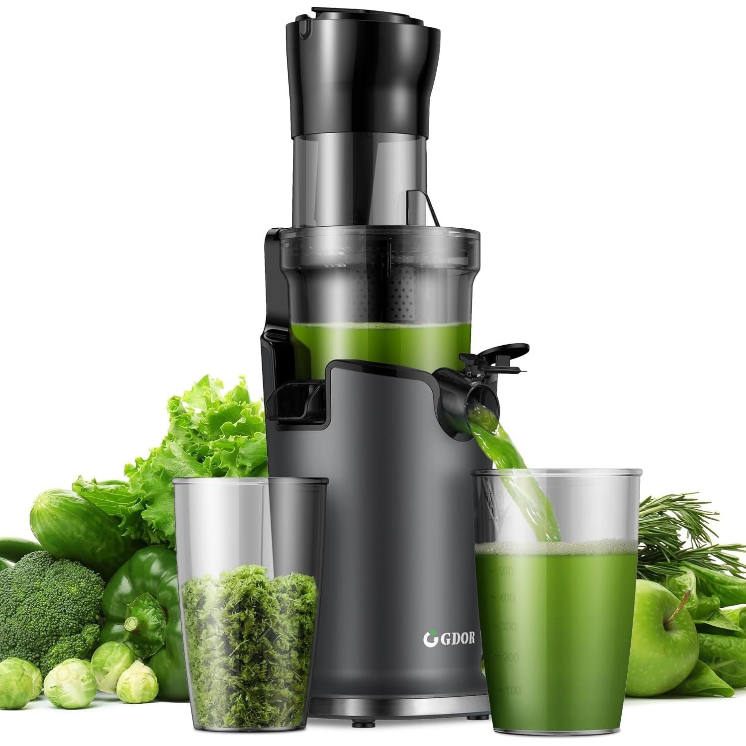 Juicer with green vegetables and a glass of green juice on a white background