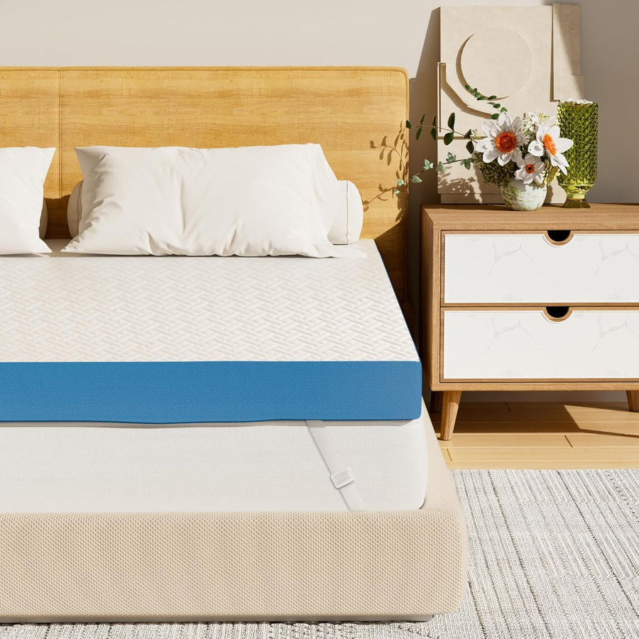 Bed with white mattress, blue band, and beige border in a bedroom setting.
