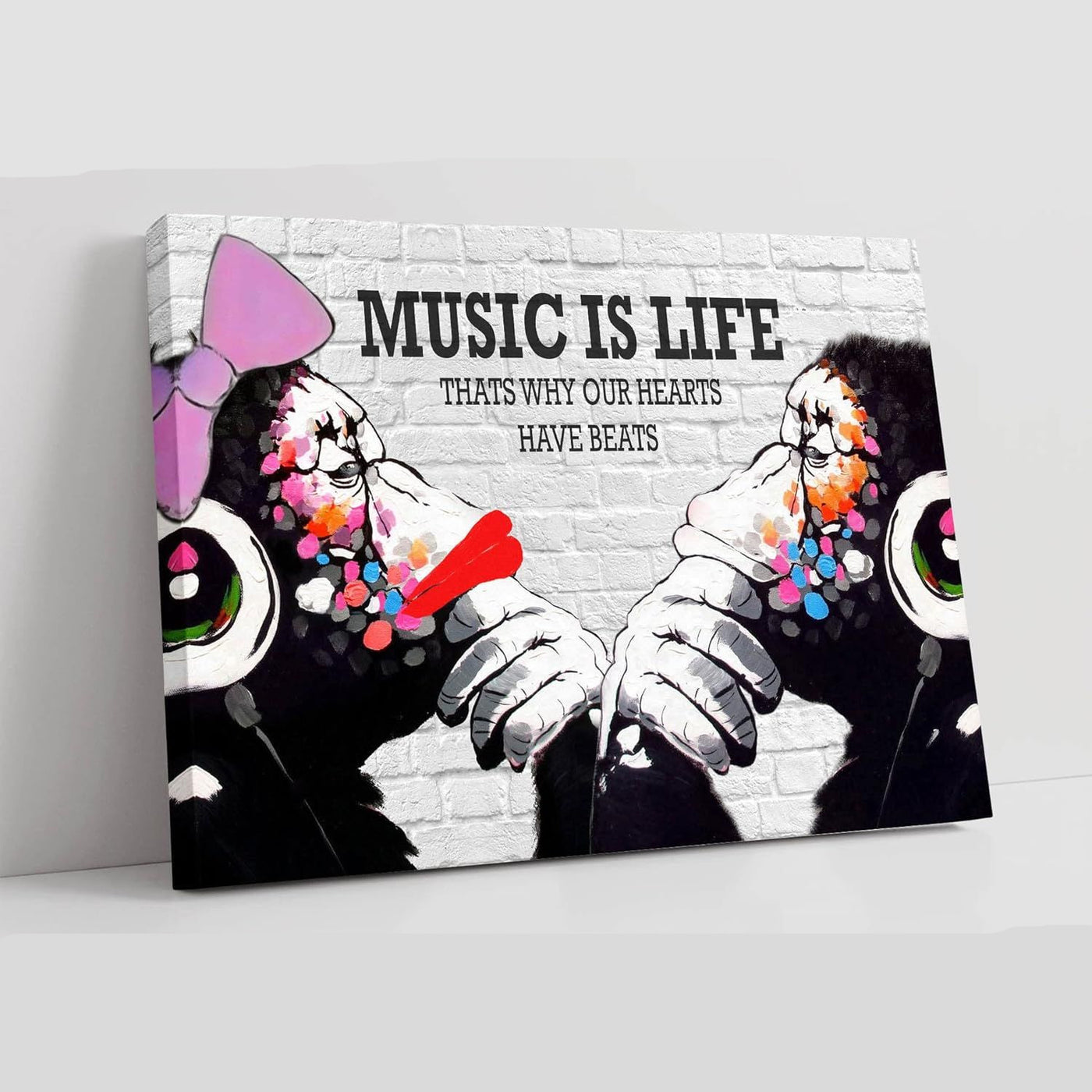 Canvas print with two monkeys wearing headphones and text 'Music is Life, That's why our hearts have beats' on a white background.