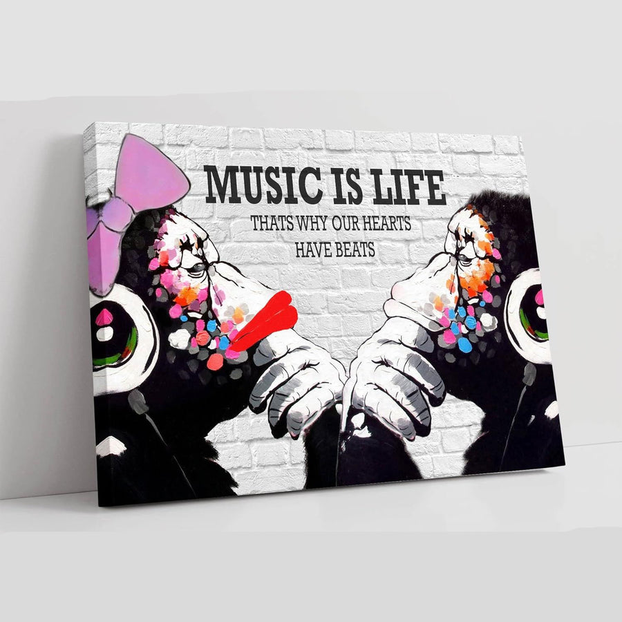 Canvas print with two monkeys wearing headphones and text 'Music is Life, That's why our hearts have beats' on a white background.