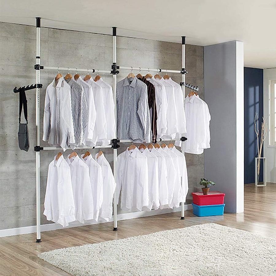 Clothing rack with shirts in a room with a concrete wall and wooden floor.