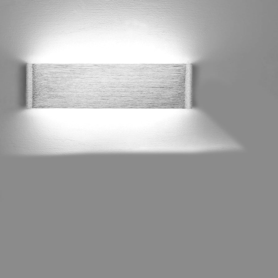 Wall-mounted light fixture casting a shadow on a gray wall