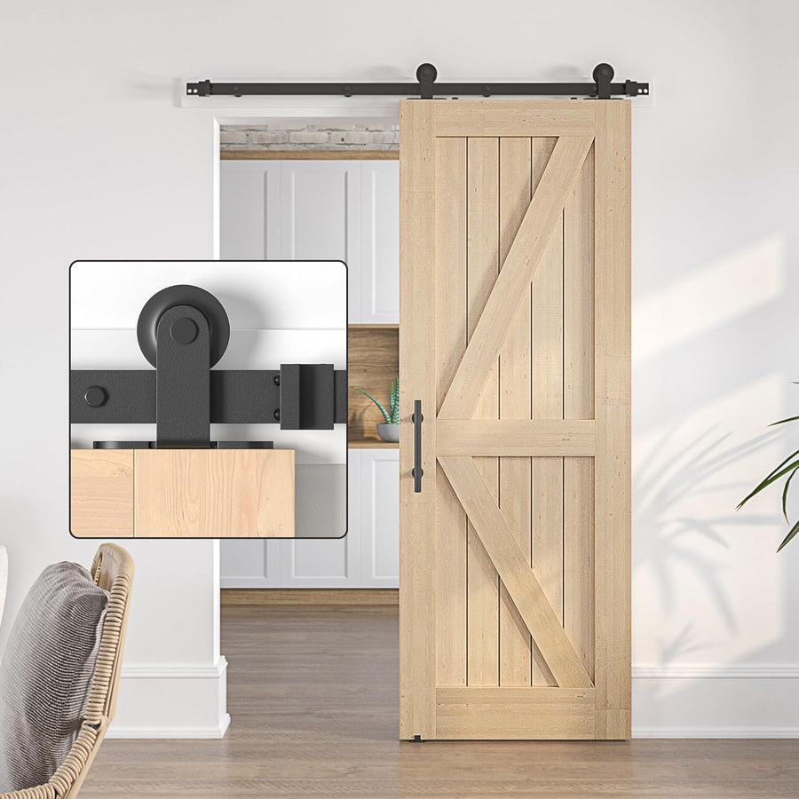 Wooden barn door with black sliding mechanism in a room setting.