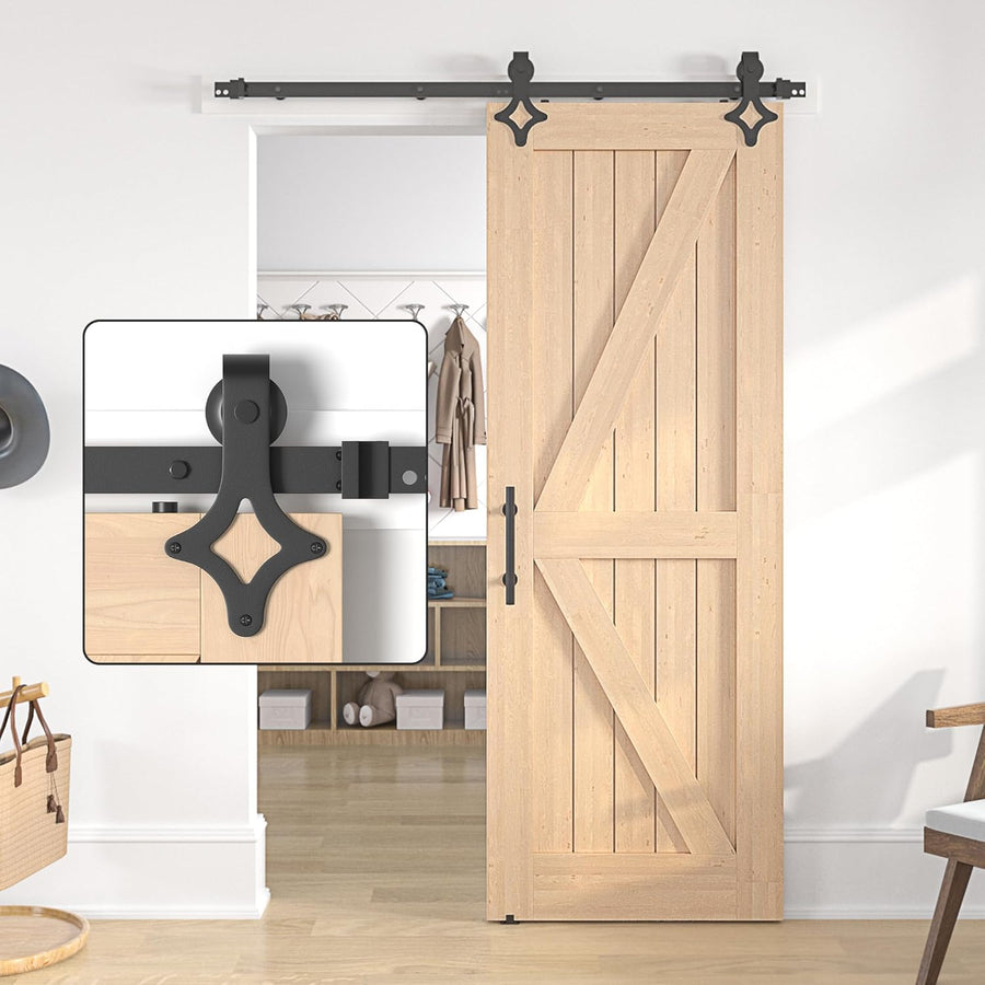 Wooden sliding barn door with black hardware in a room setting.