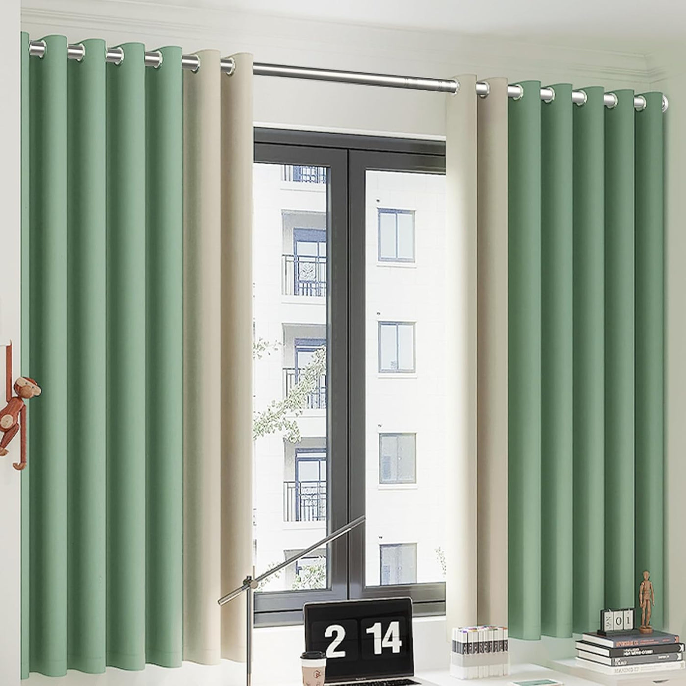 Green and beige curtains on a window with a desk and decor items in the foreground.