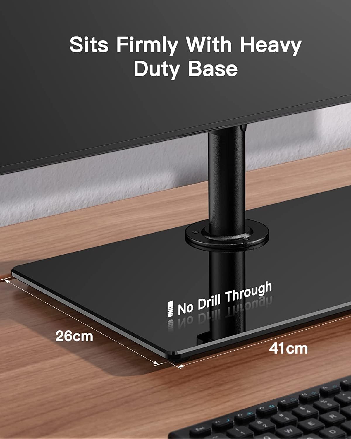 Computer monitor stand with text 'Sits Firmly With Heavy Duty Base' and measurements on a desk.