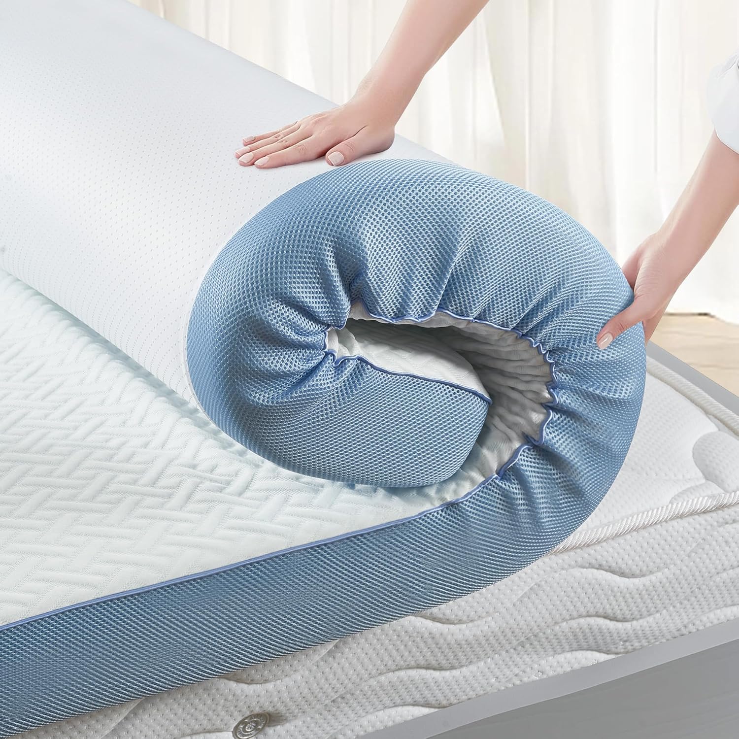 Blue mattress protector being fitted onto a bed