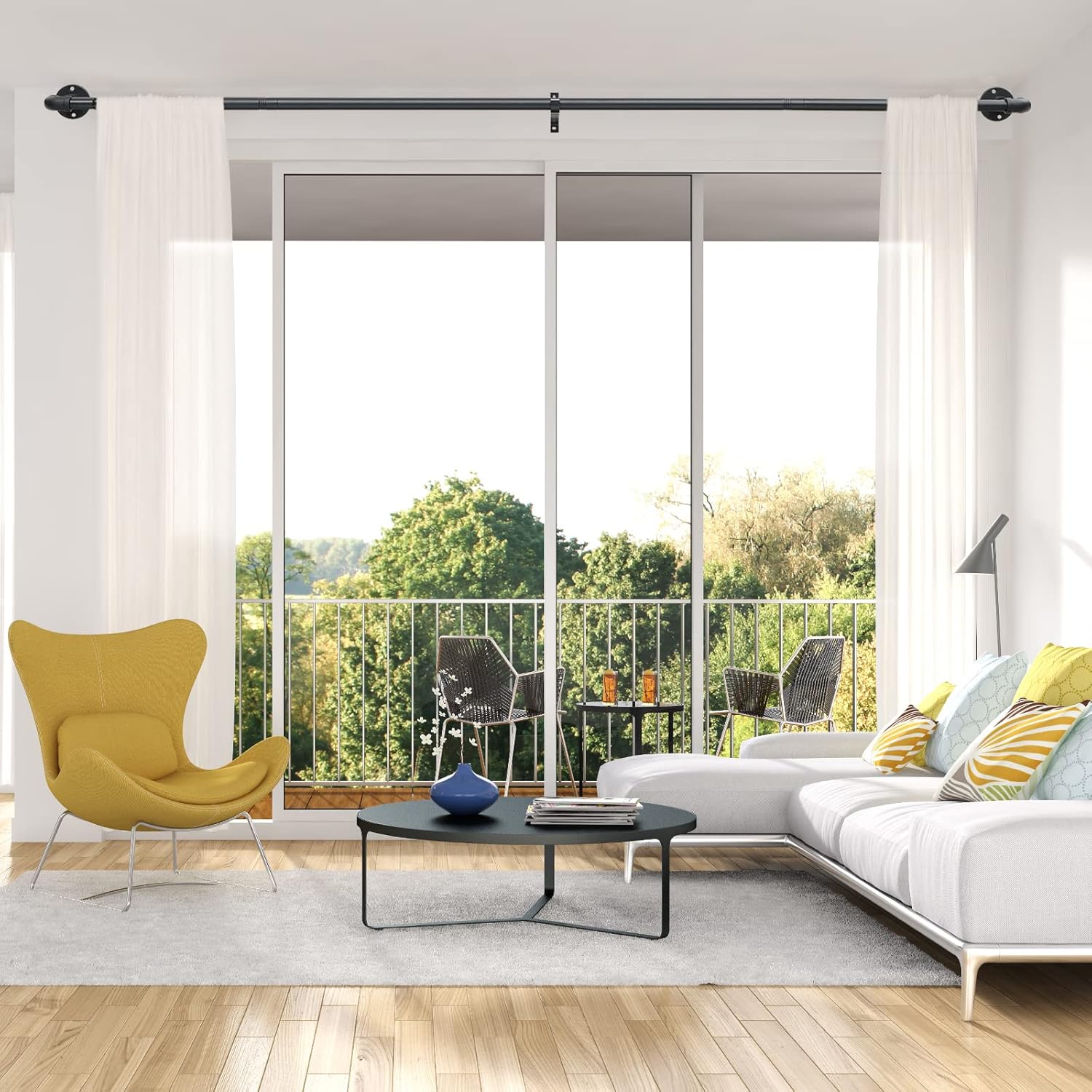 Modern living room with a yellow chair, white sofa, and glass doors leading to a balcony.