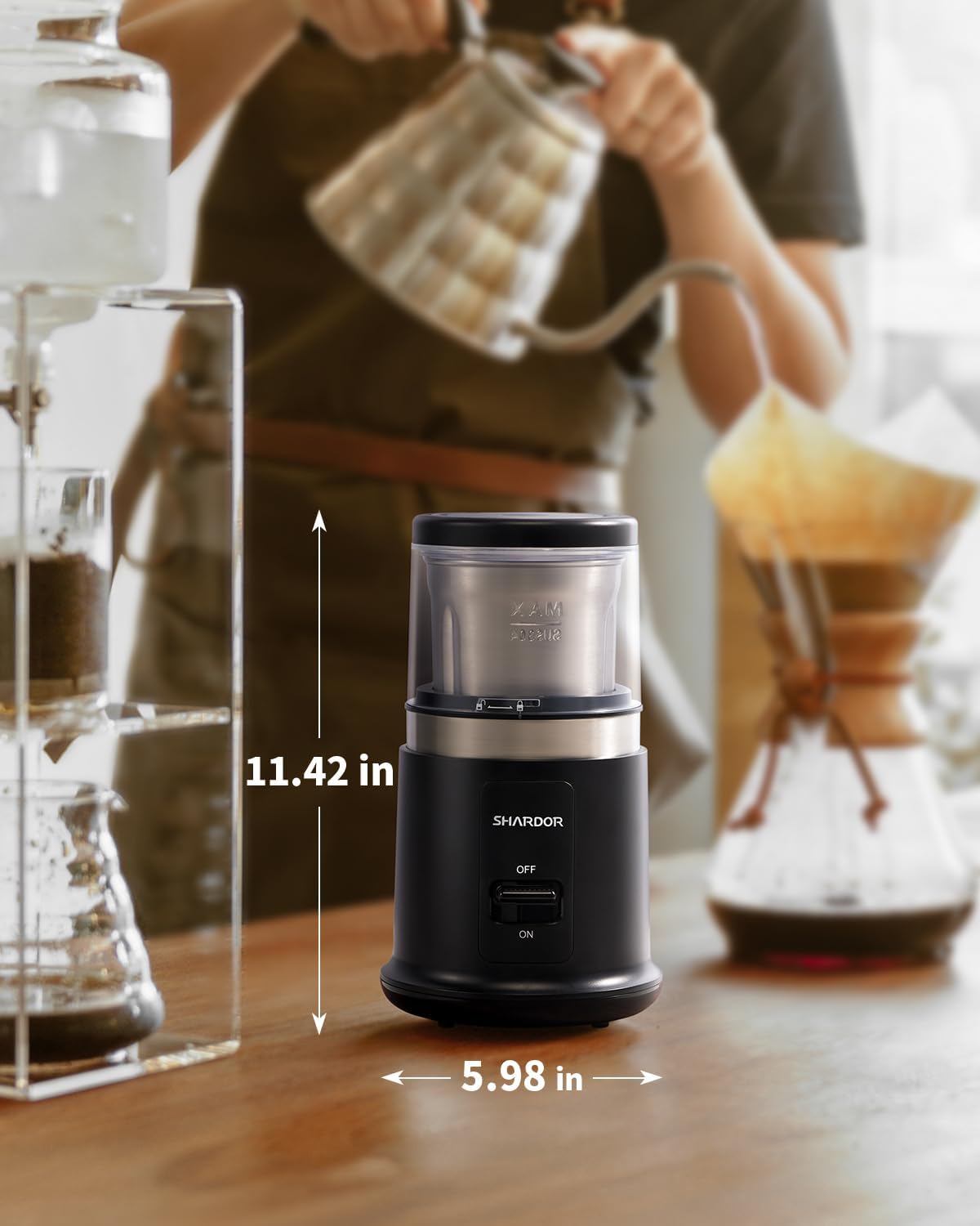 Black coffee grinder on a wooden surface with measurements indicated