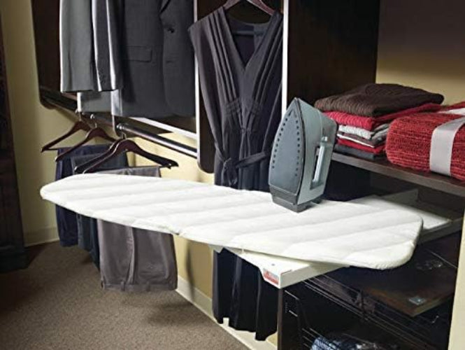 White ironing board with clothes and an iron in a closet setting