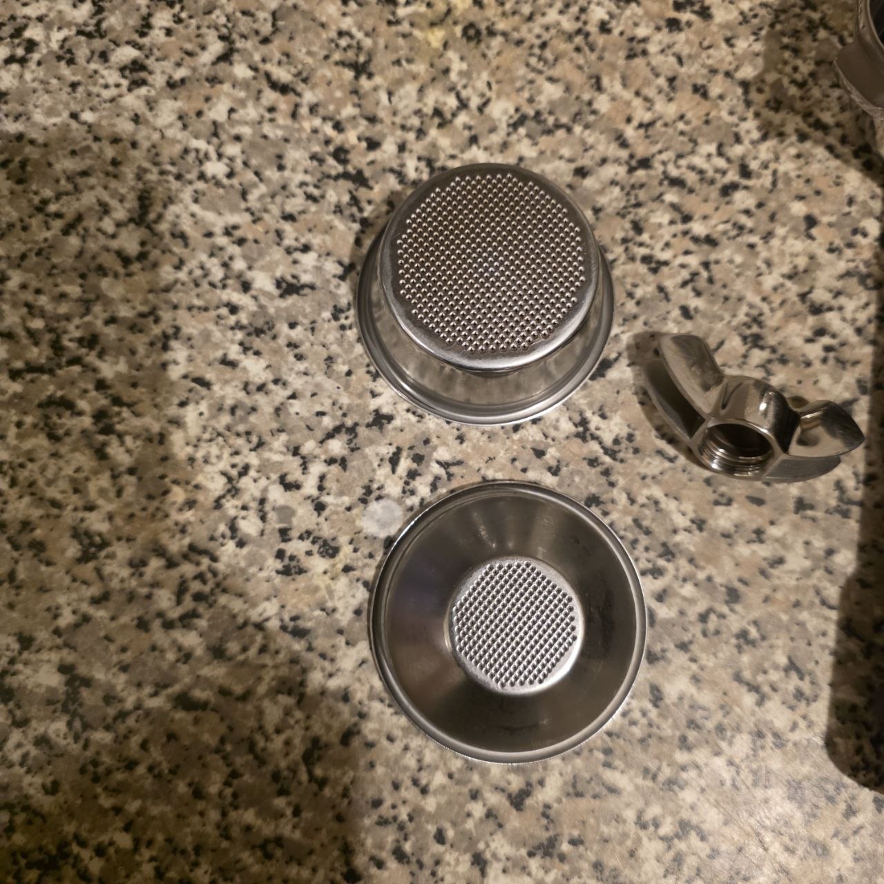 Metallic kitchen components on a speckled countertop
