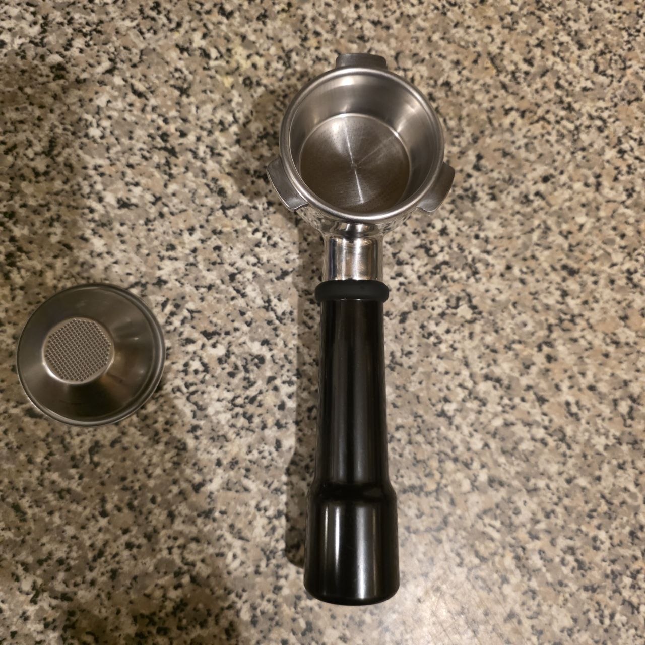 Coffee scoop with black handle on a granite countertop