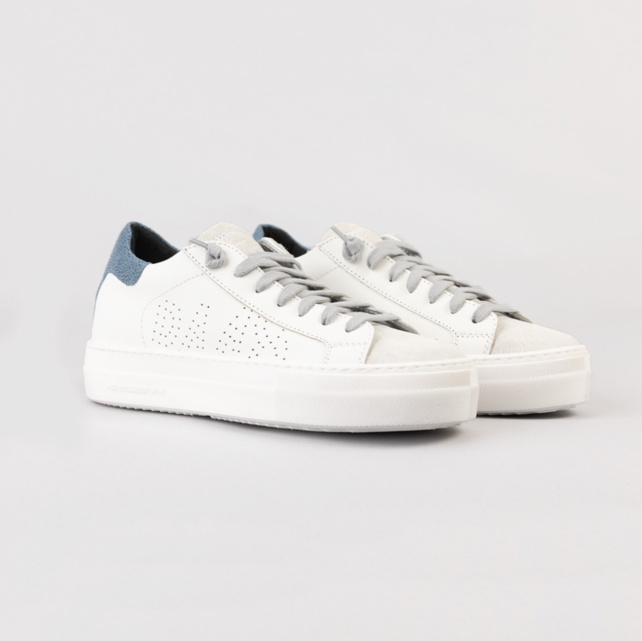 White sneakers with blue accents on a light gray background