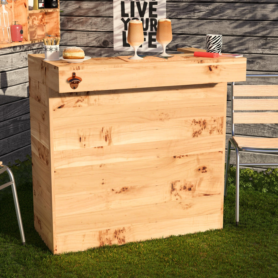 Wooden outdoor bar with drinks and a bottle opener on a grassy area.