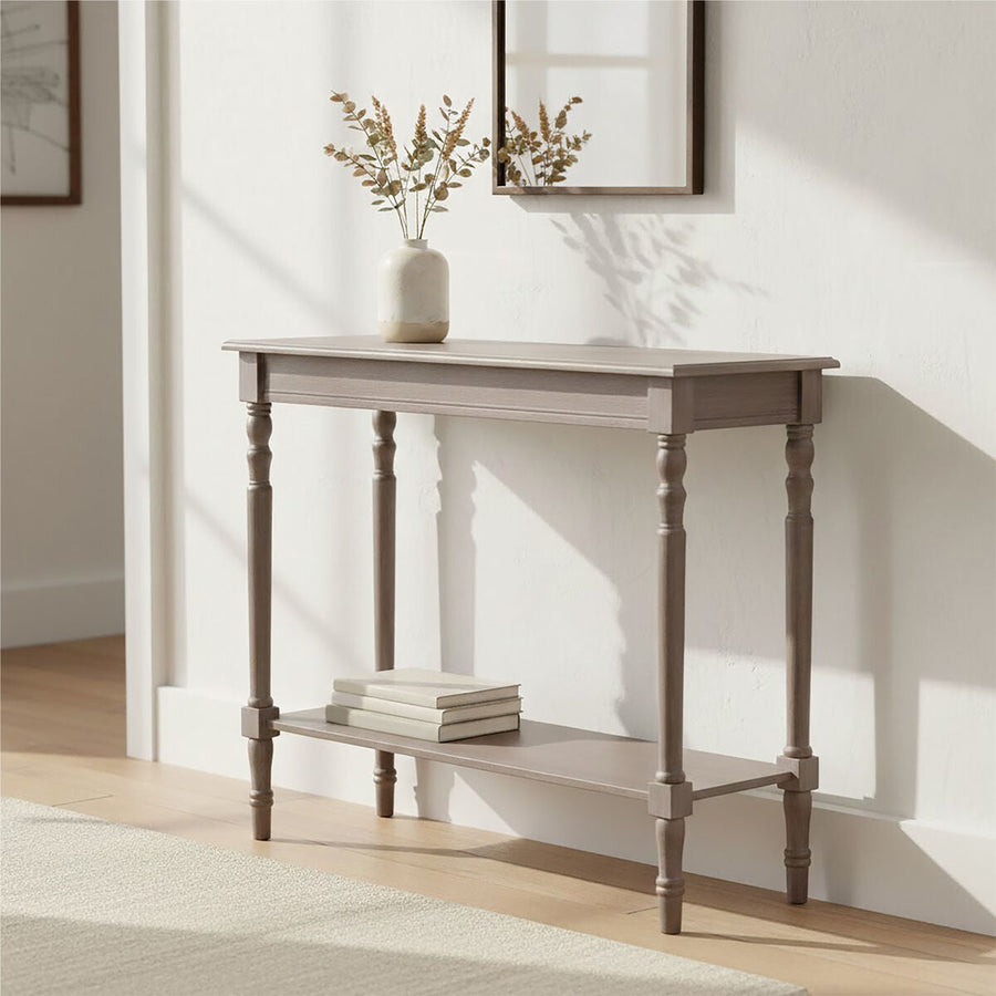 Wooden console table with a vase and books in a room with light-colored walls.