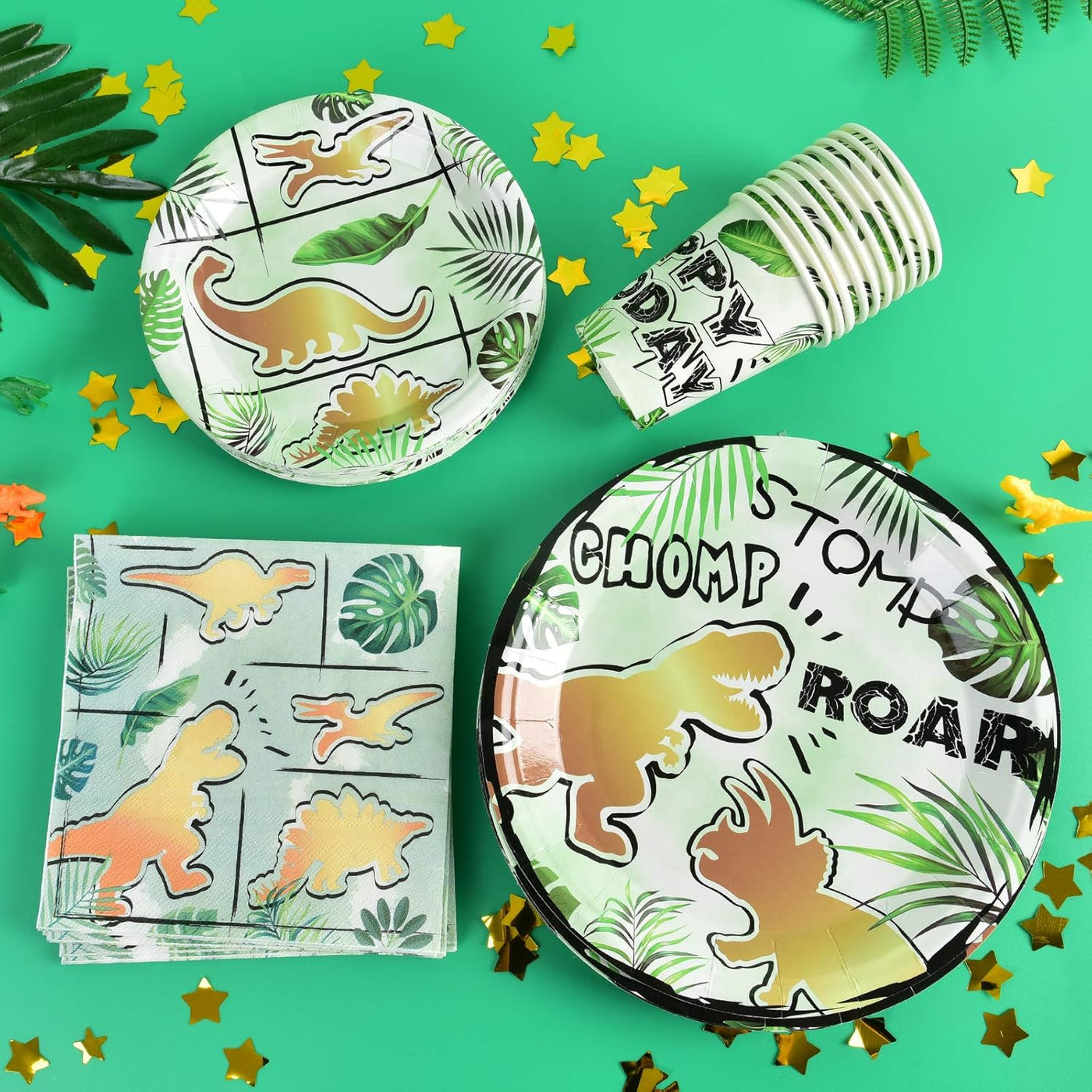 Dinosaur-themed party supplies including plates, cups, and napkins on a green background with star confetti.