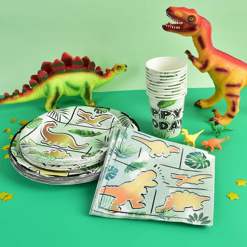 Dinosaur-themed party supplies including plates, cups, and napkins on a green background.
