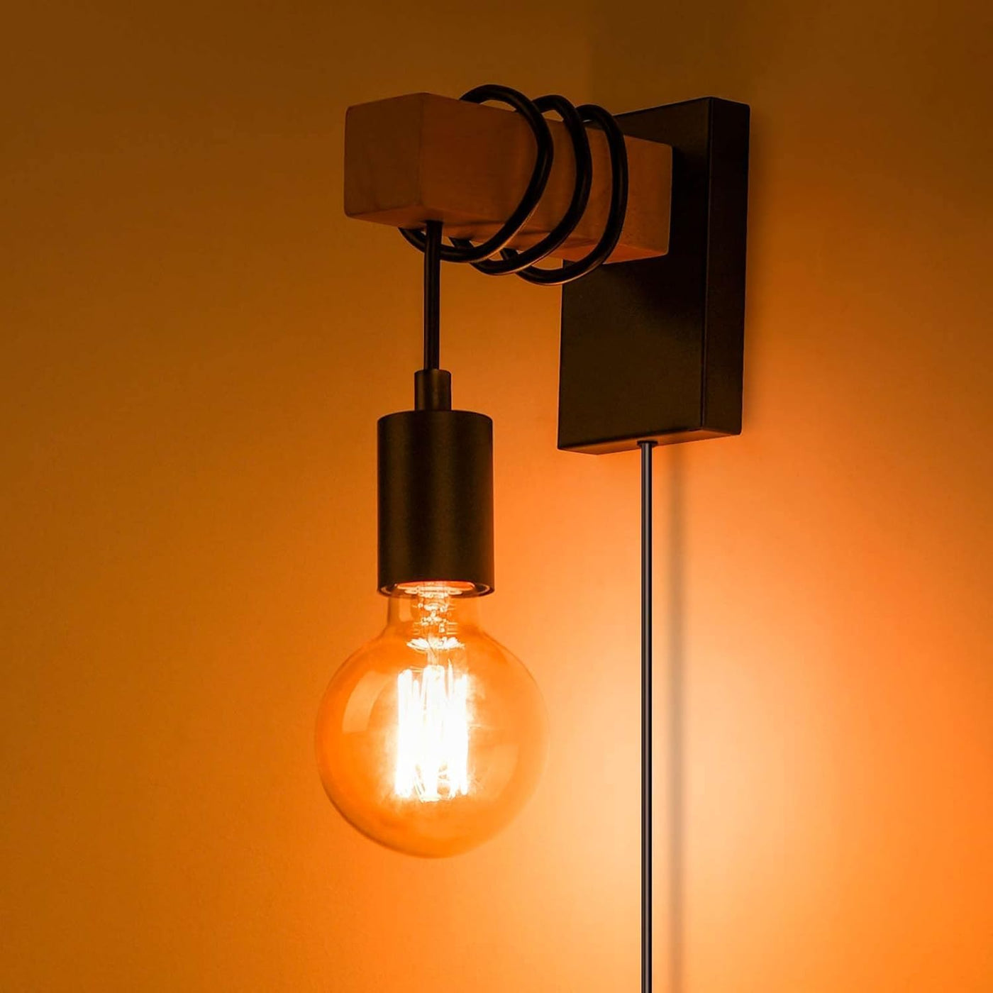 Wall-mounted light fixture with a glowing bulb on an orange background