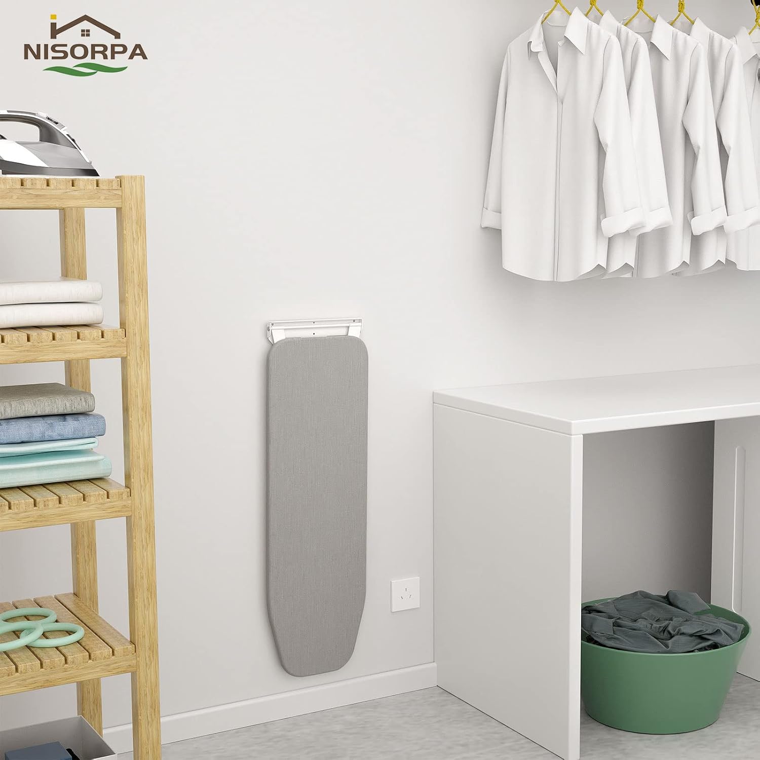 Gray ironing board against a white wall with a wooden shelf and hanging clothes in the background.