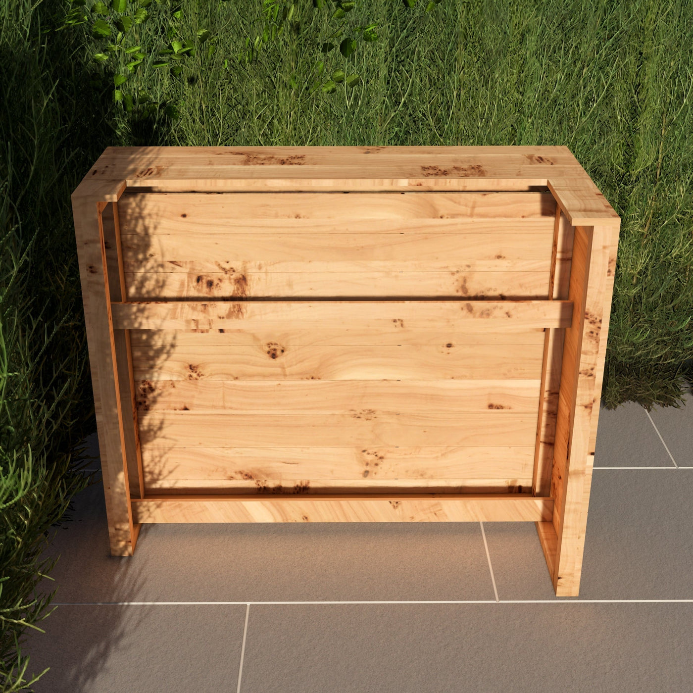 Wooden planter box on a tiled floor with grass in the background