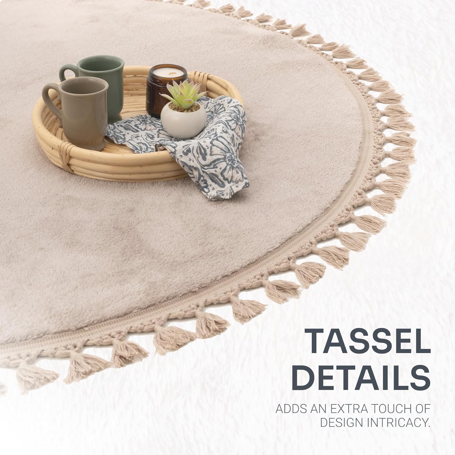 Round beige rug with tassel details, tray with cups and plant on a white background