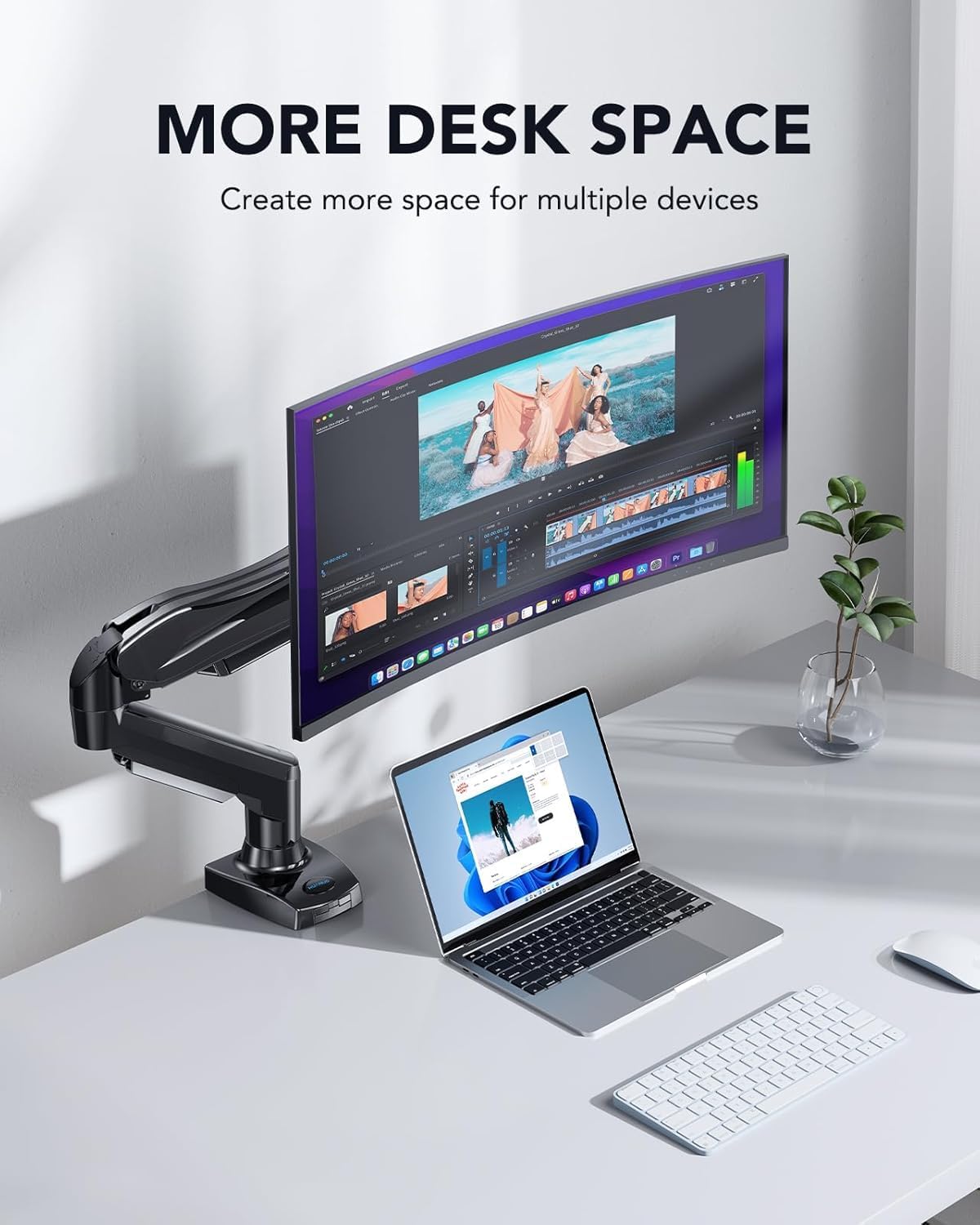 Desk setup with dual monitor stand, laptop, and keyboard on a white desk.