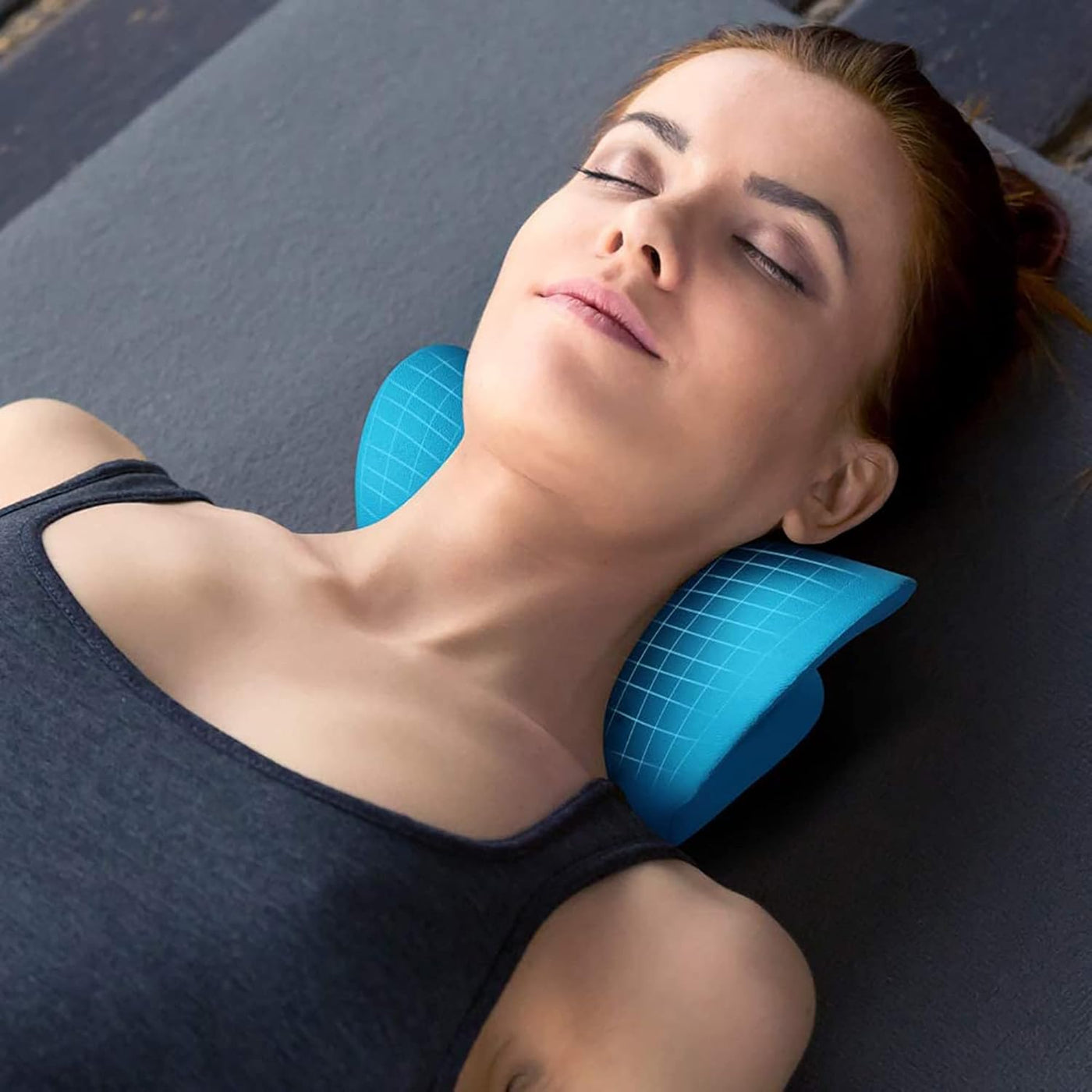 Woman lying on a mat with a blue neck pillow