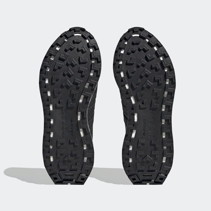 Black rubber sole of a shoe on a light gray background