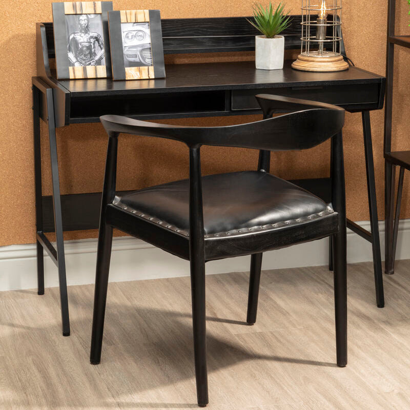 Black desk with chair against a beige wall