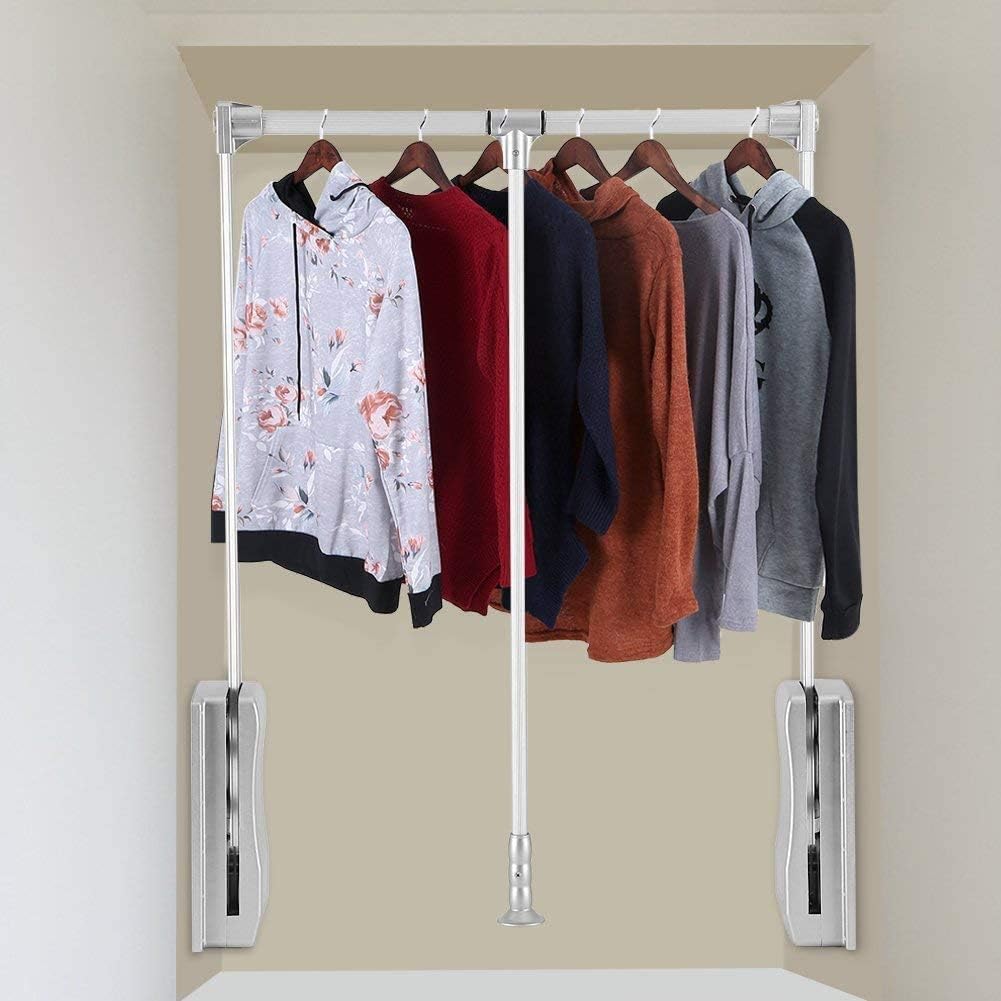 Clothing rack with hangers holding various shirts against a beige wall.