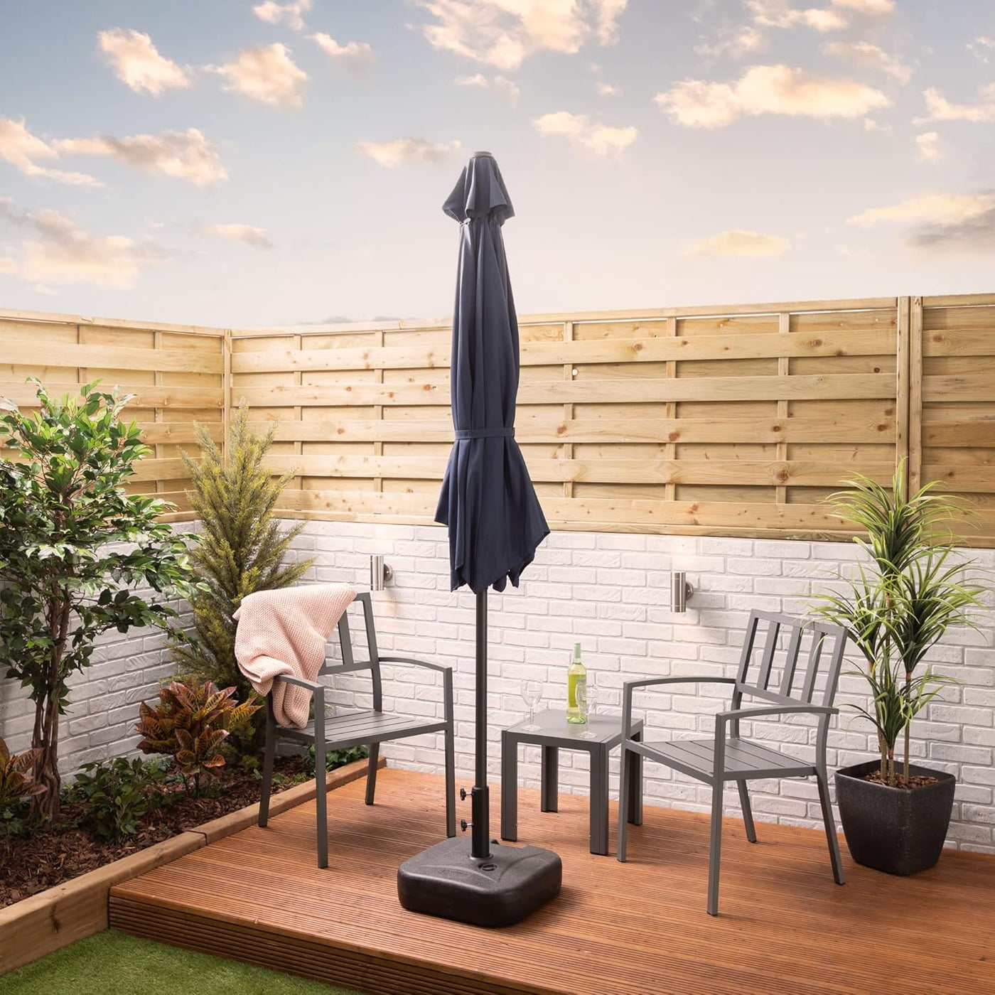 Outdoor patio set with chairs, table, and umbrella on a wooden deck.