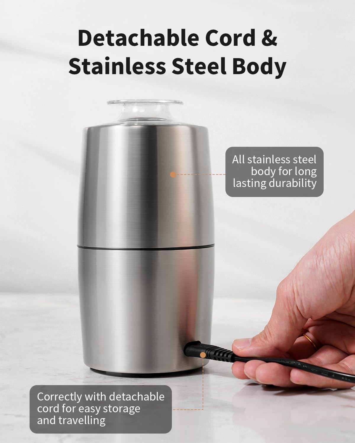 Stainless steel kitchen grinder with detachable cord on a light background