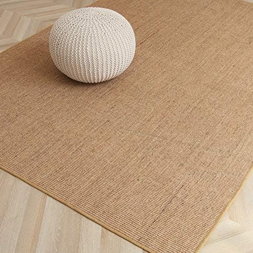 Beige woven rug with a white woven ball on a wooden floor.