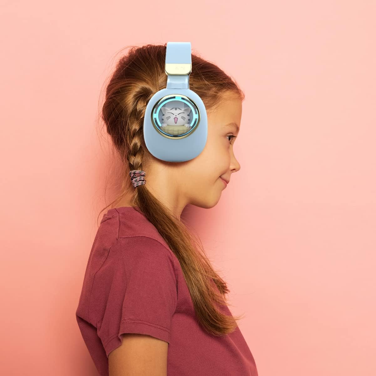Child wearing a blue headset with a cat design on a pink background