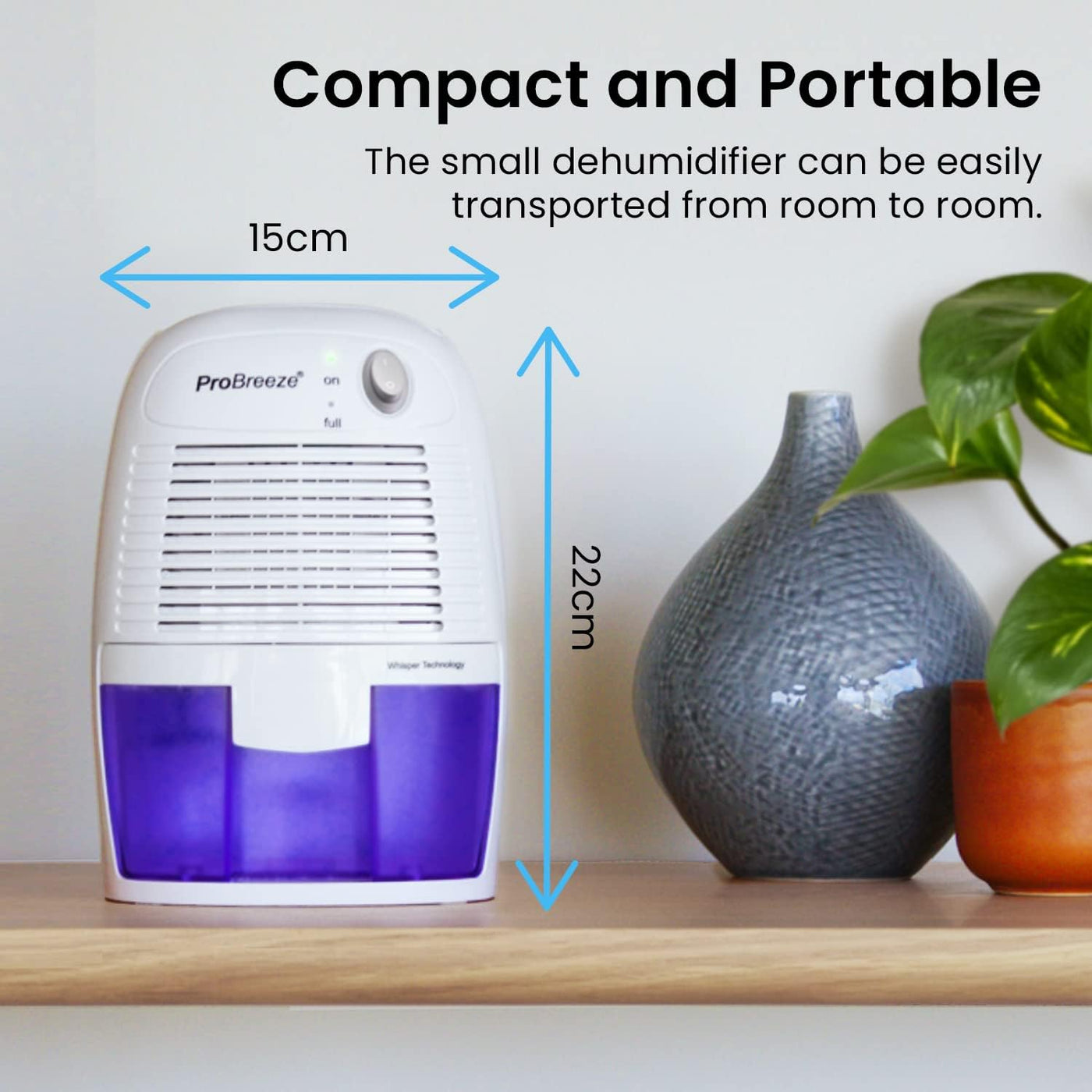 Small dehumidifier with dimensions labeled on a shelf next to a vase and plant