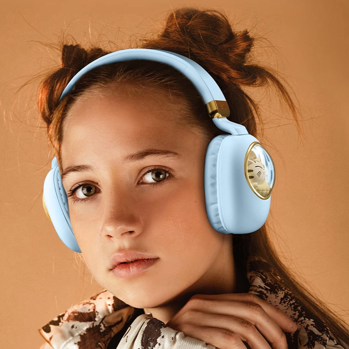 Young girl wearing light blue headphones against a beige background